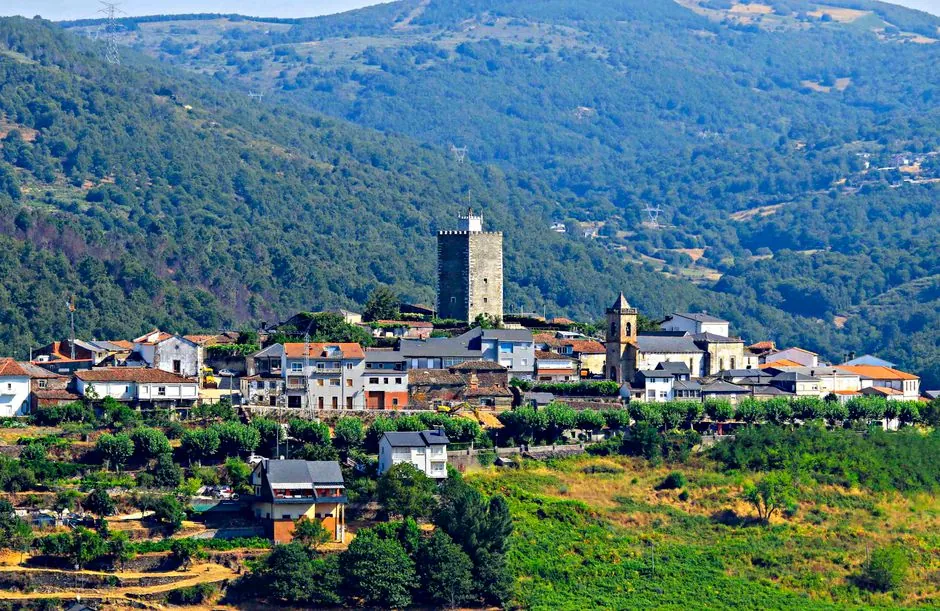 Picturesque landscape of Viana do Bolo village with historic tower and lush mountains.