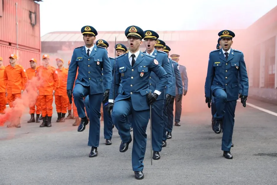 Military personnel march during a parade with firefighters, showcasing discipline and coordination.