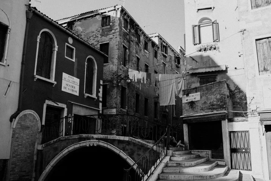 Captivating black and white photo of a historic Venetian street with timeless architecture.
