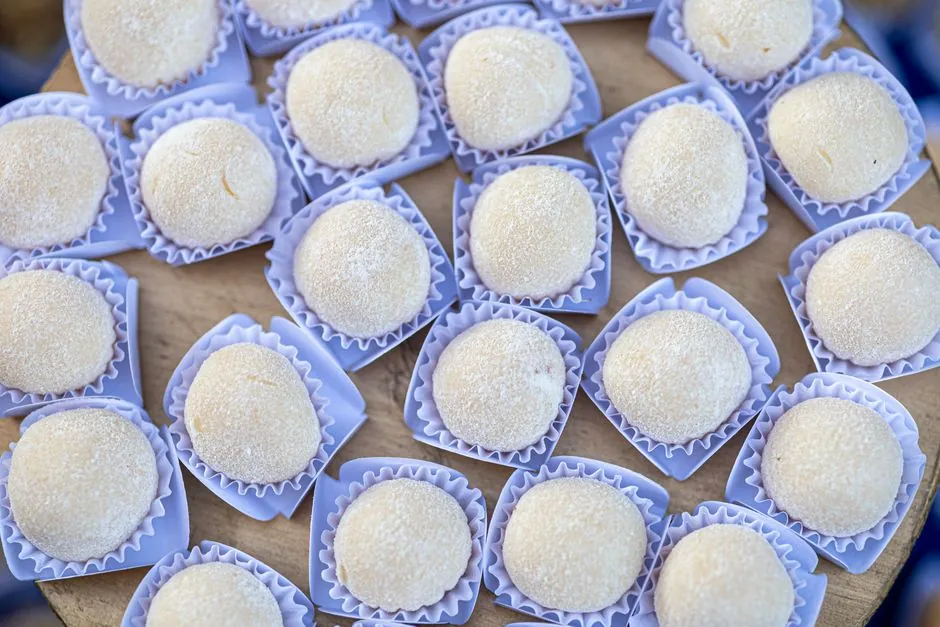 A close-up view of traditional Brazilian Beijinho coconut sweets displayed in blue wrappers.