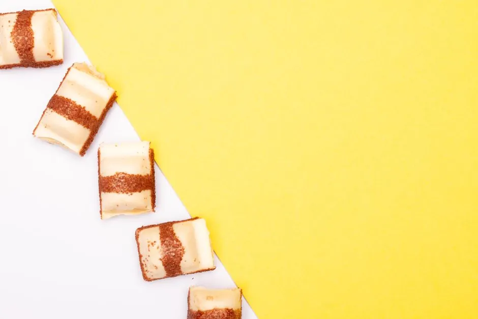 White chocolates arranged on a split yellow and white surface, perfect for food photography.