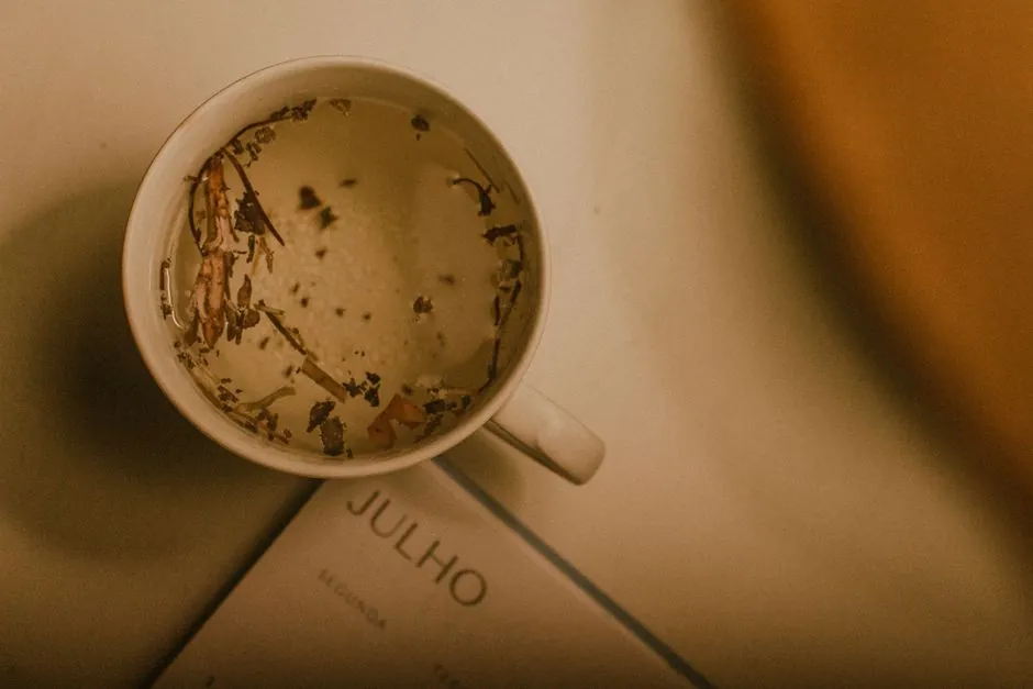 Warm herbal tea in a mug beside a July calendar page, creating an inviting and cozy atmosphere.
