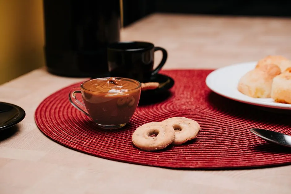 A warm coffee setup with cookies and pastries on a rustic tabletop, perfect for breakfast scenes.