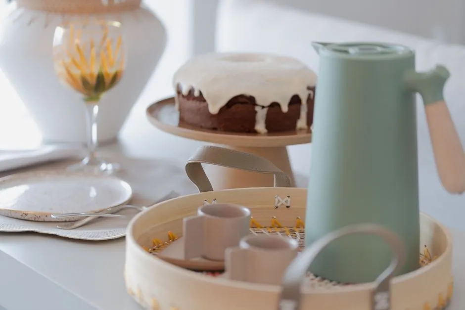 A cozy breakfast setting featuring coffee, cake, and elegant dishware in natural tones.