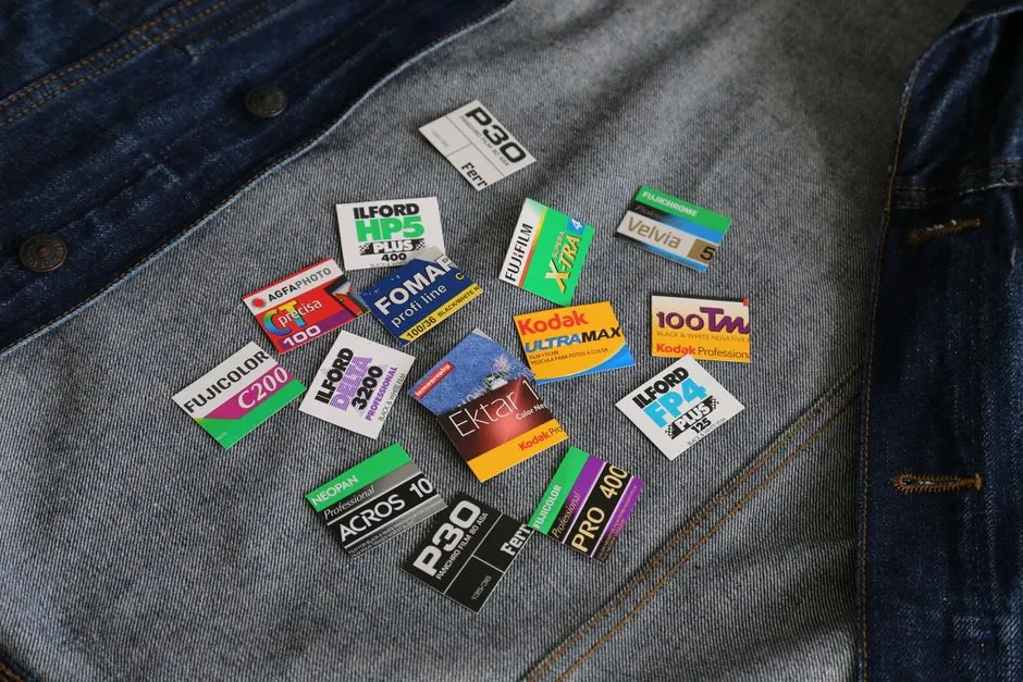 A variety of colorful vintage film labels displayed on a denim background, capturing a nostalgic essence.