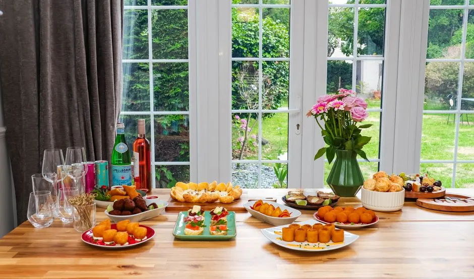 A vibrant indoor food spread with drinks and a floral centerpiece, perfect for gatherings.