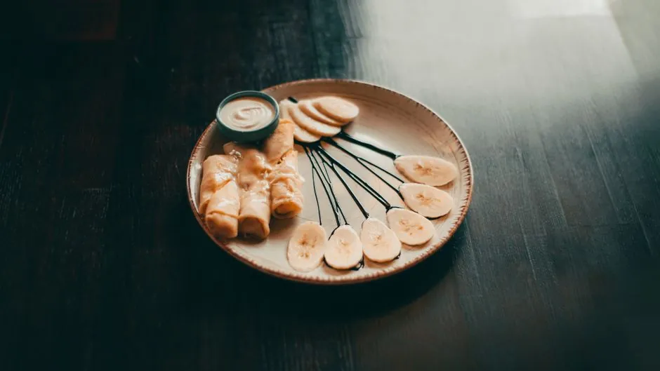 A beautifully plated dish of banana crepes and sauce, presented in a stylish manner.