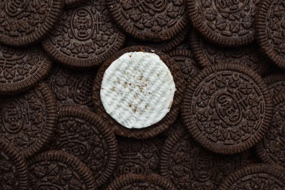 Delicious chocolate cream cookies stacked together with one missing cream top.