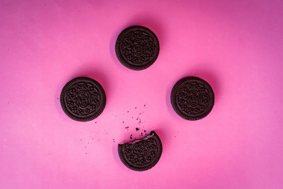 Top view of chocolate cookies arranged on a vibrant pink backdrop.