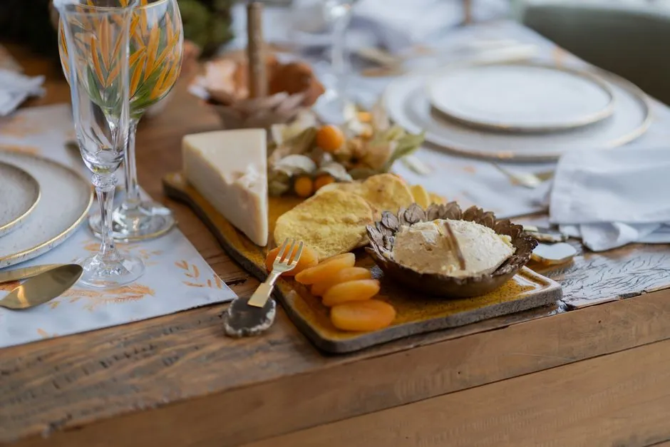 Sophisticated table setting featuring cheese and fruit platter for an elegant dinner.