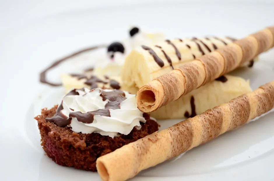 Indulgent dessert featuring chocolate, bananas, and whipped cream on a pastry.