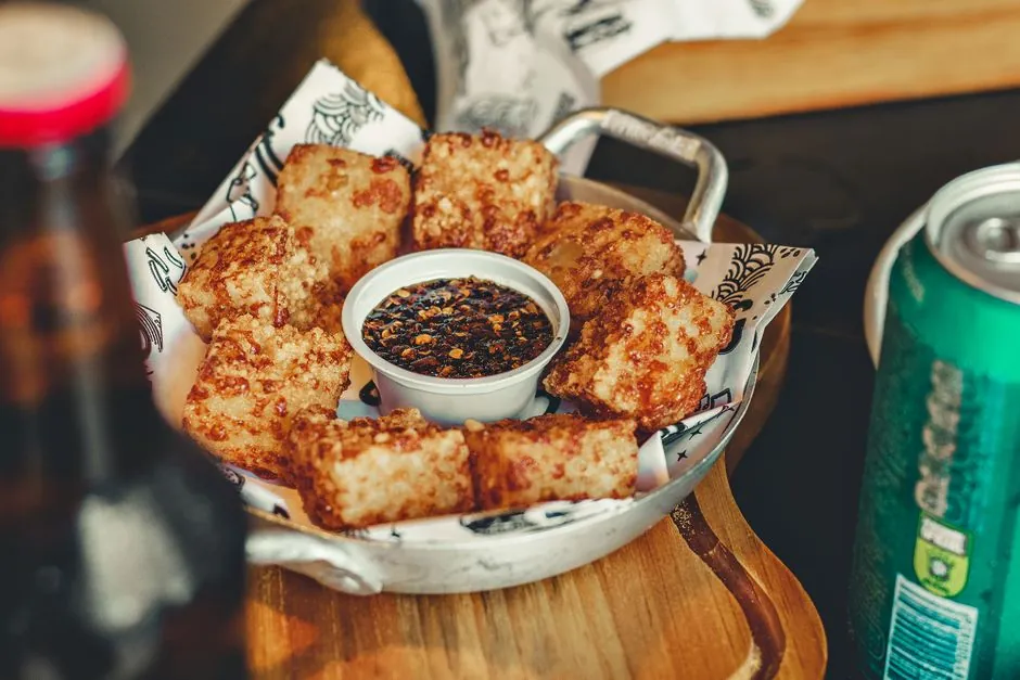 A delicious serving of deep-fried bites with dipping sauce on a restaurant table.